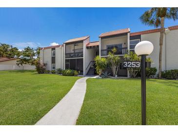 Inviting condo building with manicured lawn and charming walkway leading to the entrance at 3253 Beneva Rd # 103, Sarasota, FL 34232