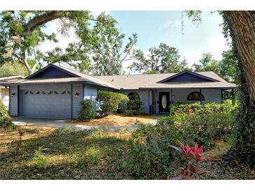 Charming one-story home featuring a well-manicured front yard, blue siding, and an attached two-car garage at 4137 Woodview Dr, Sarasota, FL 34232