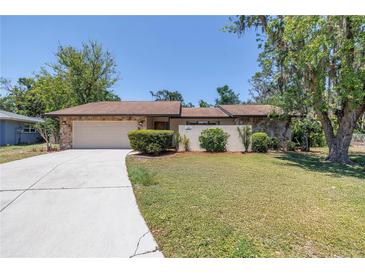 Charming single-story home featuring a stone facade, well-manicured lawn, and inviting curb appeal at 435 Whispering Oaks Ct, Sarasota, FL 34232