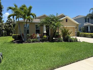 Inviting single-Gathering home featuring a lush lawn, mature palms, and colorful landscaping at 6121 35Th E Ct, Bradenton, FL 34203