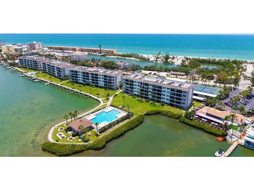 Beautiful aerial view of the condo building, pool, and Intracoastal waterway with beach access in the distance at 8897 Midnight Pass Rd # 407, Sarasota, FL 34242