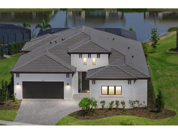 Beautiful one-story home featuring a well-manicured lawn, tile roof, and a two-car garage at 8982 Baroque Ter, Sarasota, FL 34240
