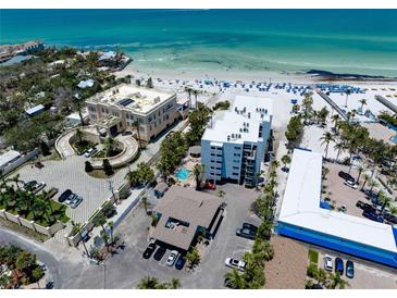Stunning aerial view of beachfront property with white sand beach and beautiful clear, blue water at 1001 Point Of Rocks Rd # 207, Sarasota, FL 34242