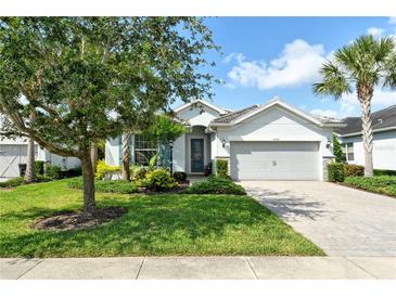 Charming single-story home with a well-manicured lawn, beautiful landscaping, and a paver driveway at 11502 Golden Bay Pl, Bradenton, FL 34211