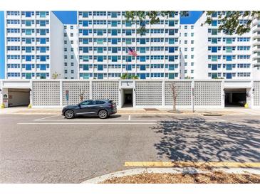 Apartment entrance featuring a light gray car parked out front, a textured white fence and a flagpole at 33 S Gulfstream Ave # 306, Sarasota, FL 34236