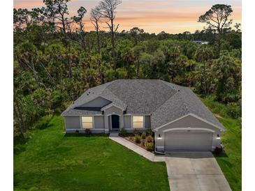 Charming single-story home featuring a well-manicured lawn and a two-car garage at 4091 Dull St, North Port, FL 34286