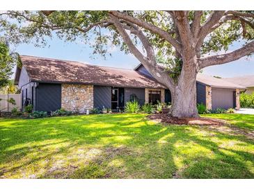 Charming single-story home featuring stone accents, fresh landscaping and a large shade tree at 4612 Masefield Pl, Sarasota, FL 34241