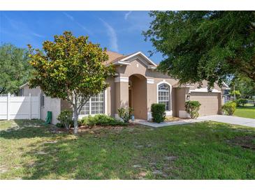 Charming single-story home with a well-manicured lawn, mature trees, and a welcoming entryway at 4951 Brightstone Pl, Spring Hill, FL 34609