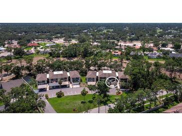 An aerial view of townhomes with a manicured landscape in a golf course community with mature trees at 6110 Country Club Way # 102, Sarasota, FL 34243