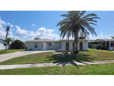 Charming single-story home with a palm tree in the front yard and a well-maintained lawn at 6360 Jordan St, North Port, FL 34287