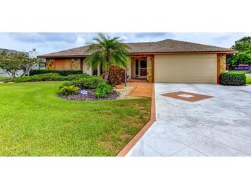 Charming single-story home featuring a well-manicured lawn, lush landscaping, and a two-car garage at 8402 13Th Nw Ave, Bradenton, FL 34209