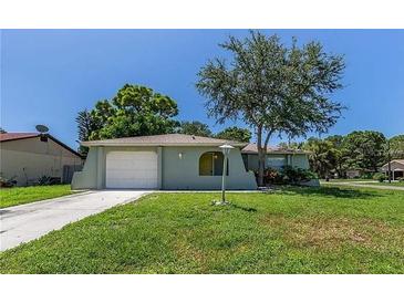 Charming single-story home featuring a well-maintained lawn, attached garage and tasteful landscaping at 8730 Filson Pl, Sarasota, FL 34231