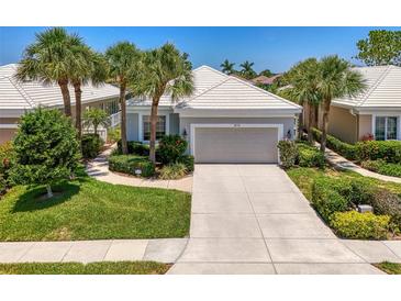 Charming home with a well-manicured front yard, complemented by lush landscaping and swaying palm trees at 8731 52Nd E Dr, Bradenton, FL 34211