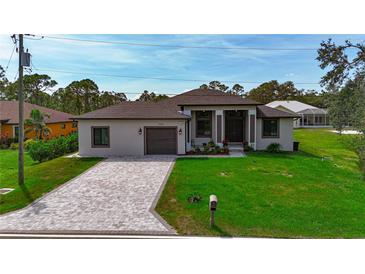 Beautiful single Gathering home with a paver driveway and well manicured lawn at 11960 De Leon Dr, North Port, FL 34287