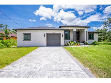 Charming single Gathering home featuring a stone driveway, a two-car garage, and well manicured landscaping at 11960 De Leon Dr, North Port, FL 34287