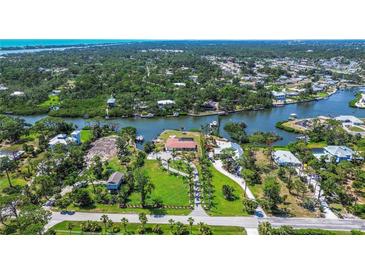 Expansive aerial view of waterfront property with lush landscaping and private canal access at 1475 Bayshore Dr, Englewood, FL 34223