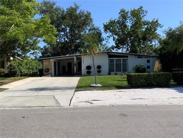 Charming single-story home with modern design elements, mature trees, and a well-maintained front lawn at 1801 Marilyn Ave, Bradenton, FL 34207