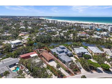 Stunning aerial view of a waterfront property with lush landscaping and a peek of the ocean at 30 Island Cir, Sarasota, FL 34242