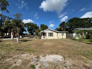 Modest single-Gathering home with a small front yard, surrounded by mature trees under a bright, partly cloudy sky at 322 34Th W St, Bradenton, FL 34205