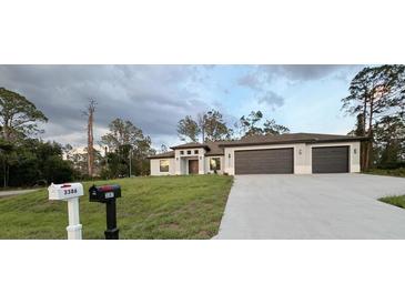 Charming single-story home with a well-manicured lawn and a two-car garage showcases a modern design at 3386 Irma St, North Port, FL 34291