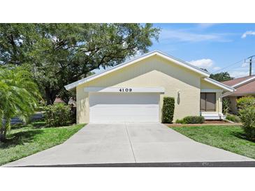 Inviting single-story home featuring an attached two-car garage and concrete driveway at 4109 Carriage Dr # 23, Sarasota, FL 34241
