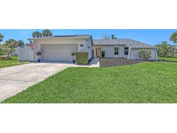 Charming home featuring a two-car garage, meticulously landscaped front yard, and an inviting walkway to the front door at 4308 Kingston Loop, Sarasota, FL 34238
