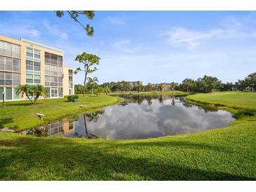 Scenic view of a pond reflecting the sky, surrounded by lush green grass and landscaping near the building at 4530 Pinebrook Cir # 109, Bradenton, FL 34209