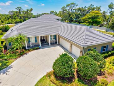 An aerial view of the home shows an expansive roofline, three-car garage and a well-manicured lawn at 5373 Anthony Ln, Sarasota, FL 34233