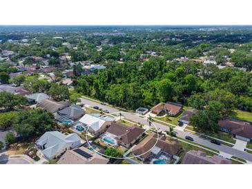 Beautiful aerial view of a home with a screened pool and lush landscaping in a desirable neighborhood at 5613 Sweetwater Oak Dr, Sarasota, FL 34232