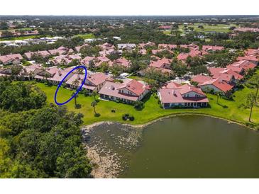 Beautiful aerial view of the home with a serene pond and lush landscaping at 7331 Villa D Este Dr, Sarasota, FL 34238