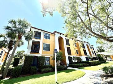 Beautiful condo building featuring balconies, lush landscaping, and a designated accessible parking area at 8341 38Th Street Cir E # 303, Sarasota, FL 34243