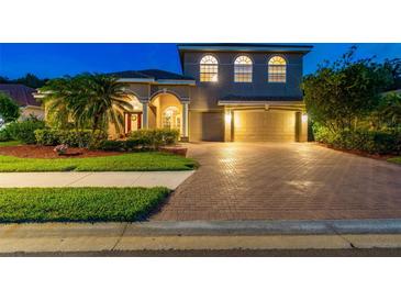 Stunning two-story home features a brick driveway, three car garage, and mature landscaping at 9008 Brookfield Ter, Bradenton, FL 34212