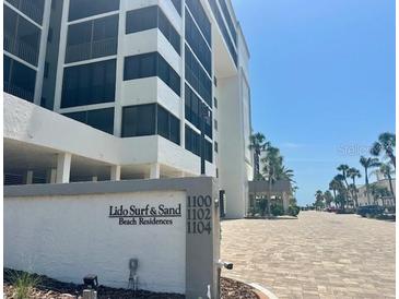 Beautiful exterior view of Lido Surf & Sand Beach Residences condo building with well-manicured landscaping at 1100 Benjamin Franklin Dr # 802, Sarasota, FL 34236