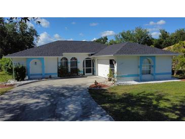 Charming single-story home with blue trim, landscaped front yard, and inviting curved driveway at 21498 Beaverton Ave, Port Charlotte, FL 33952