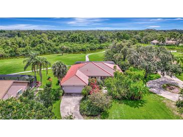 Charming single-story home featuring a red tile roof, lush landscaping, and a private driveway, nestled among mature trees at 3388 Highlands Bridge Rd, Sarasota, FL 34235