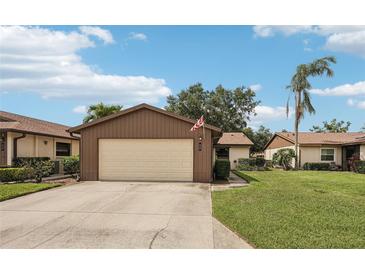 Charming single-story home featuring a two-car garage, well-maintained lawn, and mature landscaping at 532 Oak Hill Cir # 12, Sarasota, FL 34232