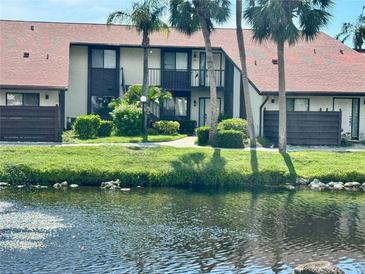 Exterior view of this two-story home with balcony and lush landscaping on a pond at 5400 34Th W St # H12, Bradenton, FL 34210