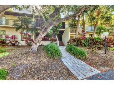 Inviting condo building with lush landscaping and a charming walkway leading to the entrance at 6501 Mourning Dove Dr # 215, Bradenton, FL 34210