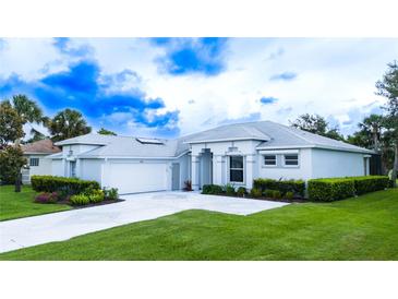 Charming single-story home with manicured lawn and lush landscaping creating excellent curb appeal at 8979 Grey Oaks Ave, Sarasota, FL 34238