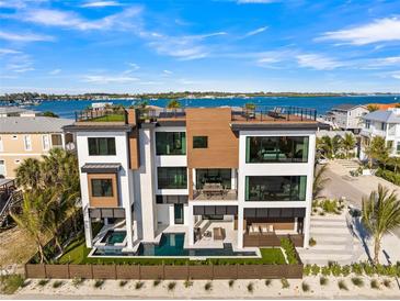 Stunning three-story home boasting a private pool, jacuzzi, and rooftop terrace with panoramic water views at 100 6Th S St, Bradenton Beach, FL 34217
