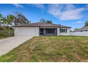 Charming single-story home with a two-car garage and a well-maintained front lawn at 1370 Mccrory St, North Port, FL 34286