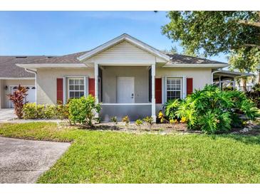 Charming single-story home with a well-maintained lawn, complemented by vibrant greenery and a cozy, covered entryway at 1516 Red Oak Ln, Port Charlotte, FL 33948
