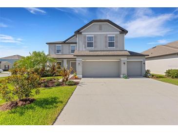 Charming two-story home with a three car garage, manicured lawn and beautiful landscaping at 2332 Mizner Bay Ave, Bradenton, FL 34208