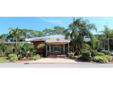 Exterior view of clubhouse with palm trees and tropical landscaping at 2650 Coconut Bay Ln # 521, Sarasota, FL 34237