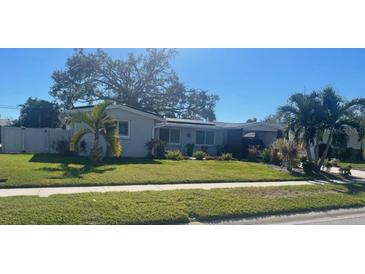 Charming single-story home featuring a well-maintained lawn and mature landscaping at 3054 Lockwood Ter, Sarasota, FL 34231