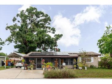 Charming single-story home featuring solar panels, a screened porch, and a covered carport at 4015 Asbury Pl, Sarasota, FL 34233