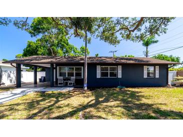 Charming single-story home features a blue facade, well-maintained lawn, and cozy front porch at 4310 7Th W Ave, Bradenton, FL 34209