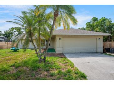 Charming single-story home with mature palm trees, a well-manicured lawn, and an attached two-car garage at 5639 Blount Ave, Sarasota, FL 34231