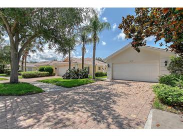 Charming home with brick driveway, lush landscaping, and two-car garage at 5787 Ivrea Dr, Sarasota, FL 34238