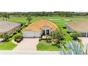 Beautiful single Gathering home with a tile roof, brick driveway and pristine landscaping, backing onto a golf course at 8206 Heritage Grand Pl, Bradenton, FL 34212